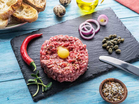 Steak tartare served with raw quail egg yolk, capers and bread. Meat dish.の写真素材