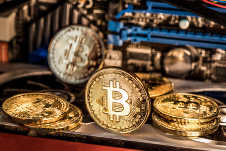 Shiny physical bitcoins and record-keeping equipment. Mining farm.