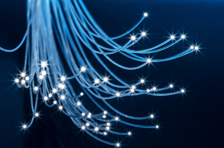 Bundle of optical fibers with lights in the ends. Blue background.の写真素材