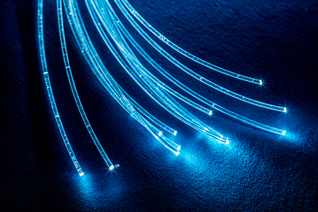 Bundle of optical fibers with lights in the ends. Blue background.の写真素材