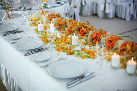 Holiday table setting decorated with flowers and candles.の写真素材