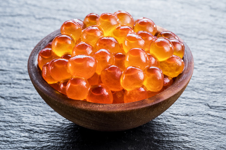 Red caviar in the bowl on gray graphite background. Macro picture.の写真素材