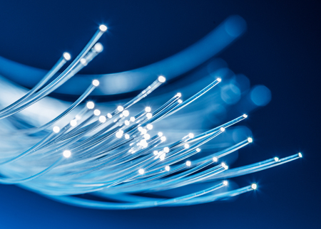 Bundle of optical fibers with lights in the ends. Blue background.の写真素材