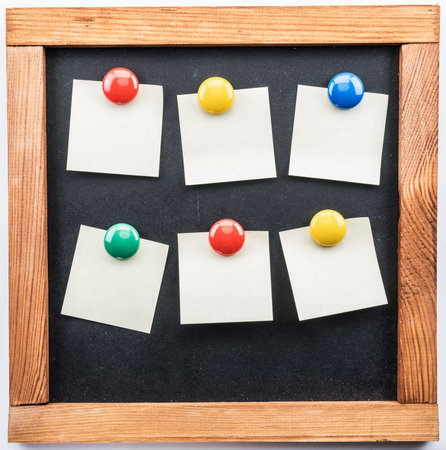 Blackboard and post-it notes stuck with colorful magnets.