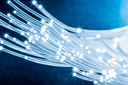 Bundle of optical fibers with lights in the ends. Blue background.の写真素材