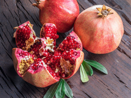 Opened ripe pomegranate fruit on wooden table. Top view.