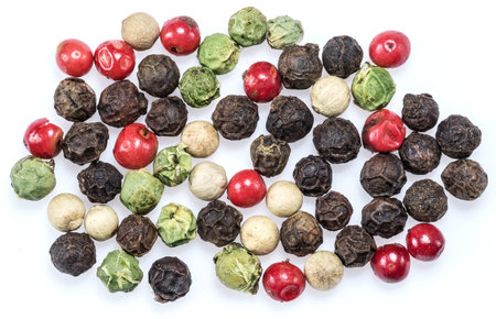Black, white, green and red peppercorns isolated on white background.