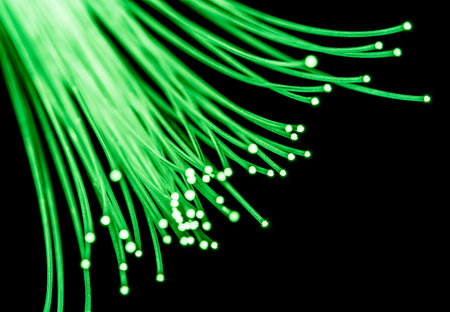 Bundle of optical fibers with green light. Black background.