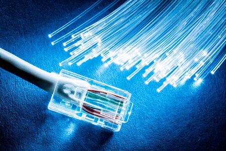 Network cable and optical fibers with lights on blueの写真素材
