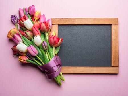 Colorful bouquet of tulips and blackboard. Spring background.の写真素材