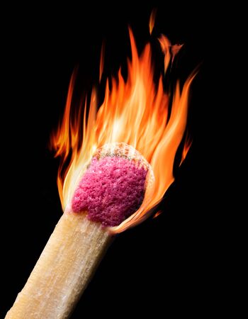 Burning match isolated on black backround. Close-up picture of head in red flames.の写真素材