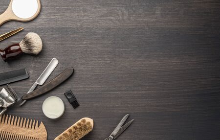 Classic grooming and hairdressing tools on wooden background. Top view on barbershop instruments  laying on dark wooden table.の写真素材