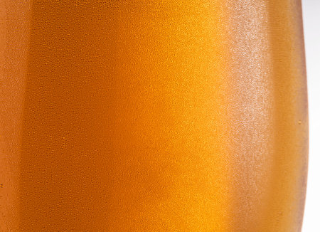 Cooled glass of beer close-up.  Small water drops on cold glass surface.