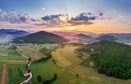 Beautiful sunset in mountains in Croatia. Bird's eye view panorama of amazing sky and the red sun lights shooting clouds over valley.の写真素材