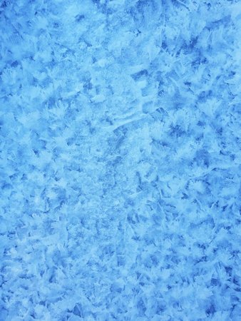 Snow crystals form beautiful snow pattern on frozen icy river. Snowflake background.