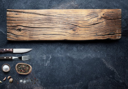 Table settings and empty wooden tray on graphite background. Top view of food background.