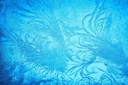 Beautiful blue frost patterns on frozen window as a symbol of Christmas wonder. Christmas or New...