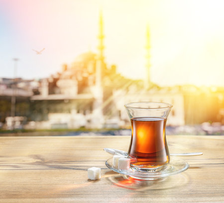 Turkish tea served in tulip-shaped glass on a small saucer blurred nature background. Summer holiday background.の写真素材