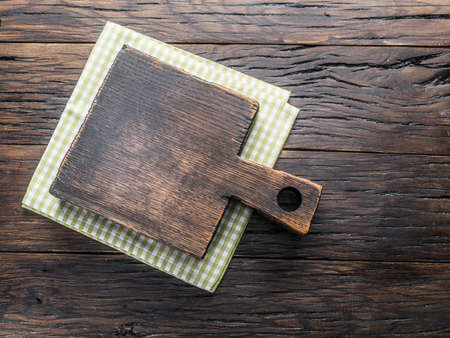 Empty cutting board on wooden table. Top view. Copy space and empty space for your food design.の写真素材