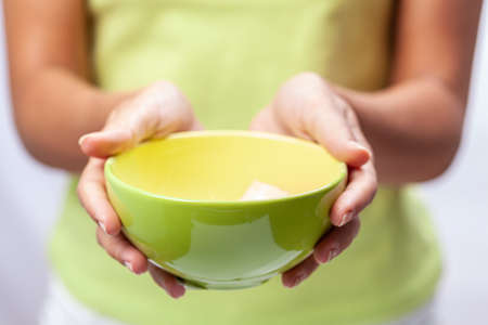 Green empty bowl in female hands, close-up photographed, shallow depth of field.の写真素材