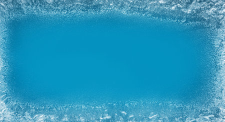Frost patterns on frozen winter window as a symbol of Christmas wonder. In the middle of the window...