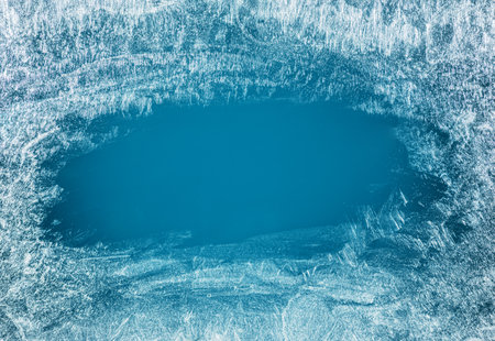 Frost patterns on frozen winter window as a symbol of Christmas wonder. In the middle of the window is a misted space for your product or lettering. Christmas or New year background.の写真素材