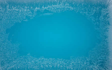 Frost patterns on frozen winter window as a symbol of Christmas wonder. In the middle of the window is a misted space for your product or lettering. Christmas or New year background.の写真素材