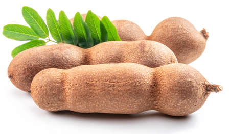 Ripe tamarind fruit pods and leaves isolated on white background.の写真素材