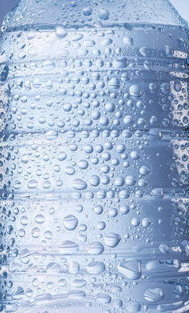 Surface of water bottle covered with condensation of drops closeup.