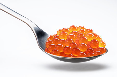 Spoon of red caviar or salmon roe isolated on white background.の写真素材