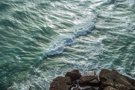 Ocean waves approaching rocky shore. top view.の写真素材