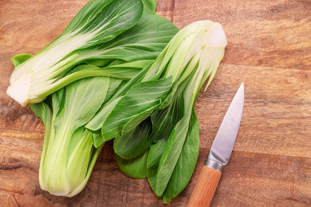 Bok choy or chinese cabbage on wooden background. View above.の写真素材