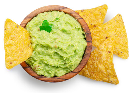 Guacamole bowl and corn chips dipped in it on white background. top view. File contains clipping path.の写真素材
