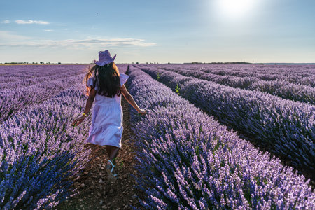 Young girl running between lavender bushes in the field. Brihuega, Spain.の写真素材