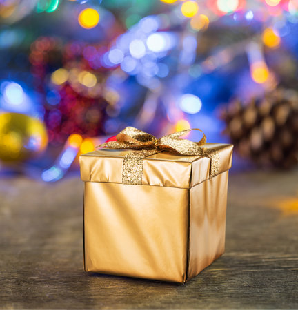 Christmas gift as the symbol of Christmas happiness and miracle. Sparkling fairy lights at the background.の写真素材