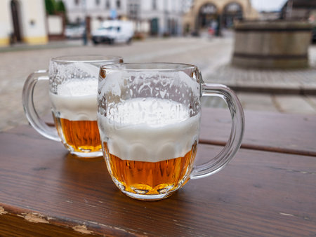 Beer mugs or beer glasses on wooden table top city at the background.の写真素材