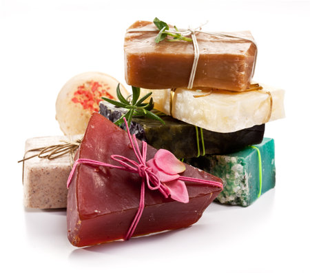 Stack of colorful handcrafted natural soaps and bath bomb tied with rustic strings on white background.の写真素材