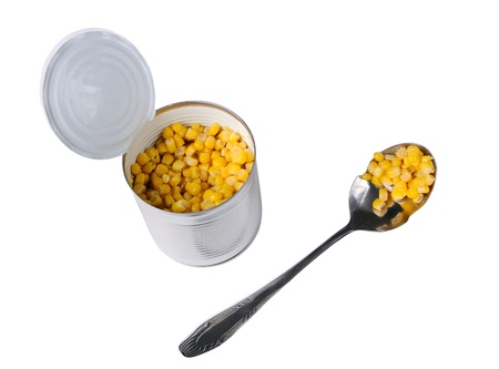 Open can with corn and a spoon isolated on whiteの写真素材