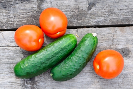 Directly above view of raw tomatoes and cucumbers on wooden tableの写真素材