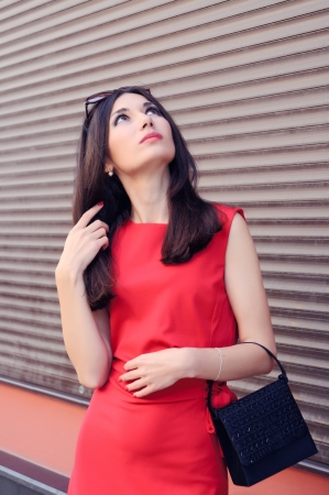 The girl in a red dress looking up の写真素材