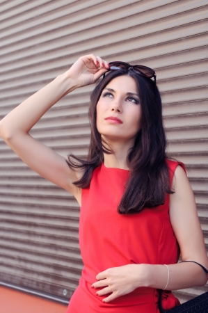 The girl in a red dress looking up の写真素材
