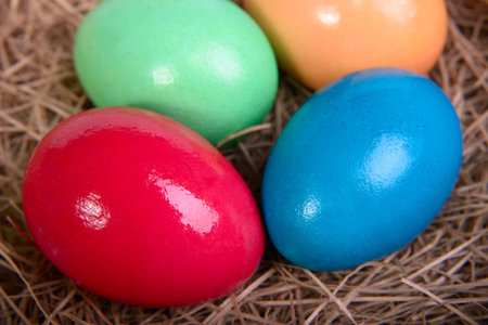 Multicolored Easter eggs on straw closeupの写真素材