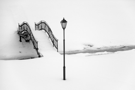 Streetlight and iron footbridge over winter creekの写真素材