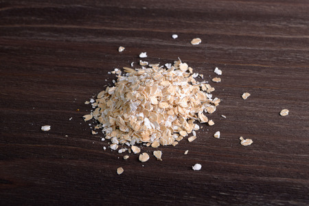 Handful of oats on a wooden backgroundの写真素材