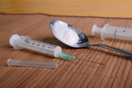 Disposable syringe and a white powder in the spoon, selective focusの写真素材