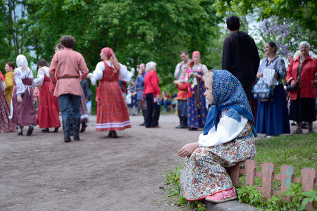 St. Petersburg, Russia - May 22, 2016: The girl in a national suit looks at dancing. An annual Nikolsky festival of folk art in St. Petersburg.のeditorial素材