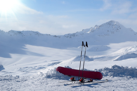 Snowboard and skis in the snow on background snowy mountainsの写真素材