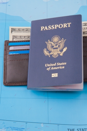 American passport and wallet with dollars cash and credit cards on map background for business travel concept  Verticalの写真素材