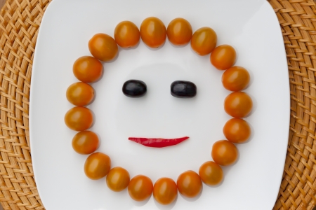 Sunny face with yellow tomatosの写真素材