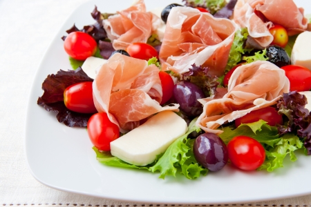 Fresh spring mix salad italian style with prosciutto and mozzarella の写真素材
